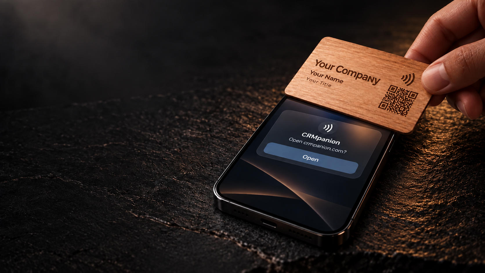 A hand tapping a wooden card labeled Your Company, Your Name, and Your Title on a phone showing an NFC link notification